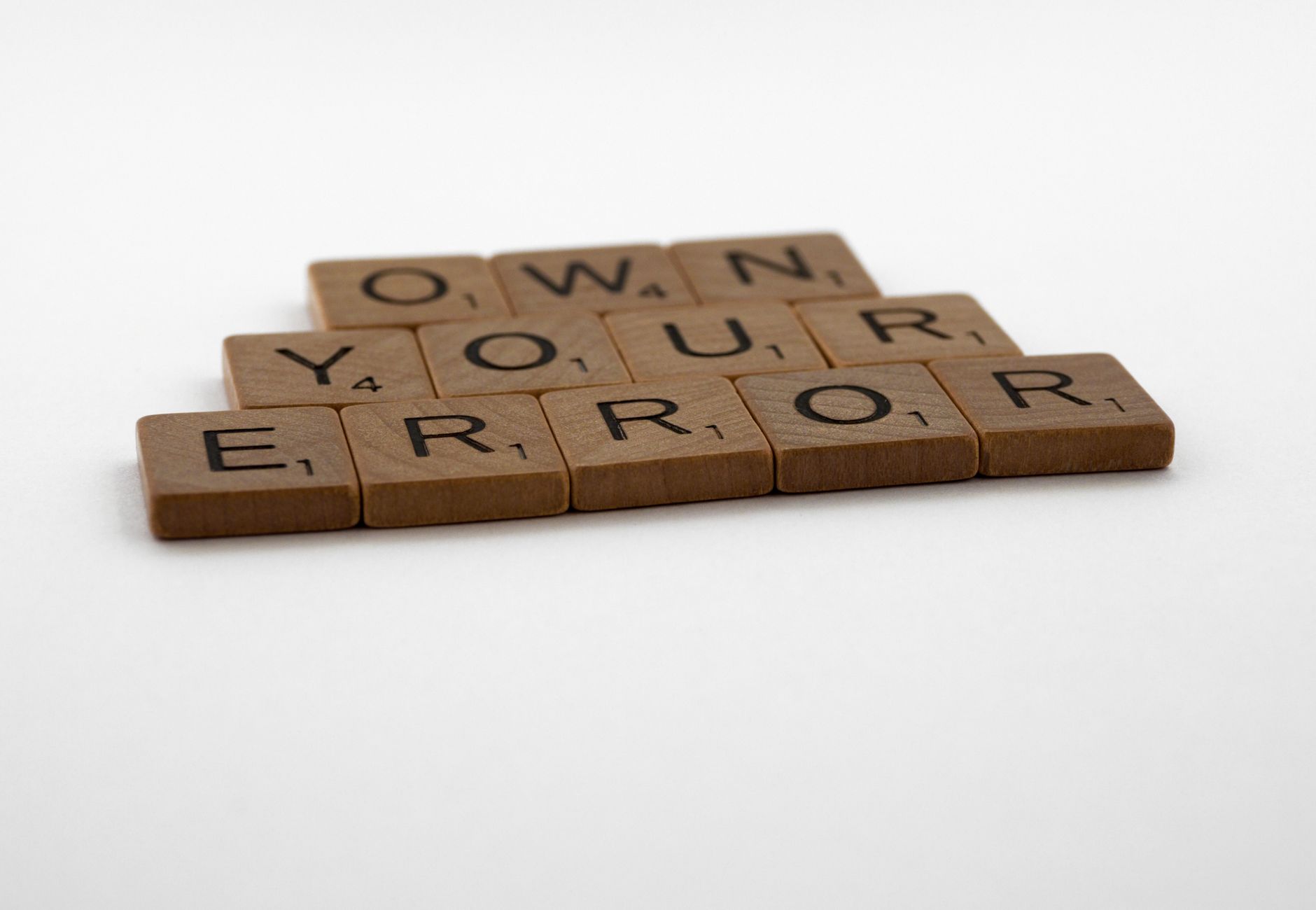 A motivational phrase assembled with Scrabble tiles on a white background.