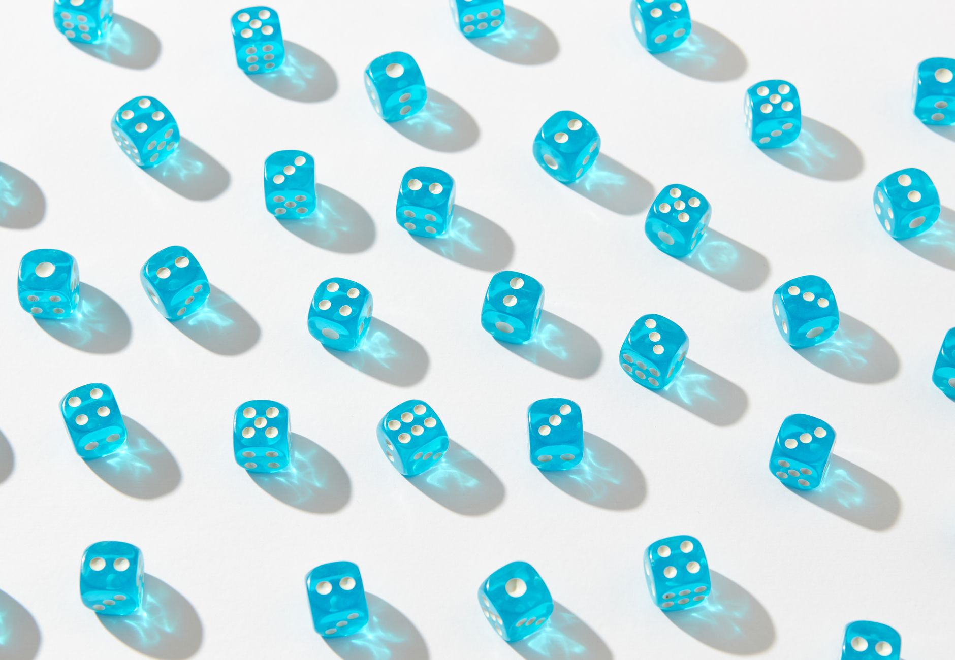 A captivating pattern of blue transparent dice casting shadows on a white surface.