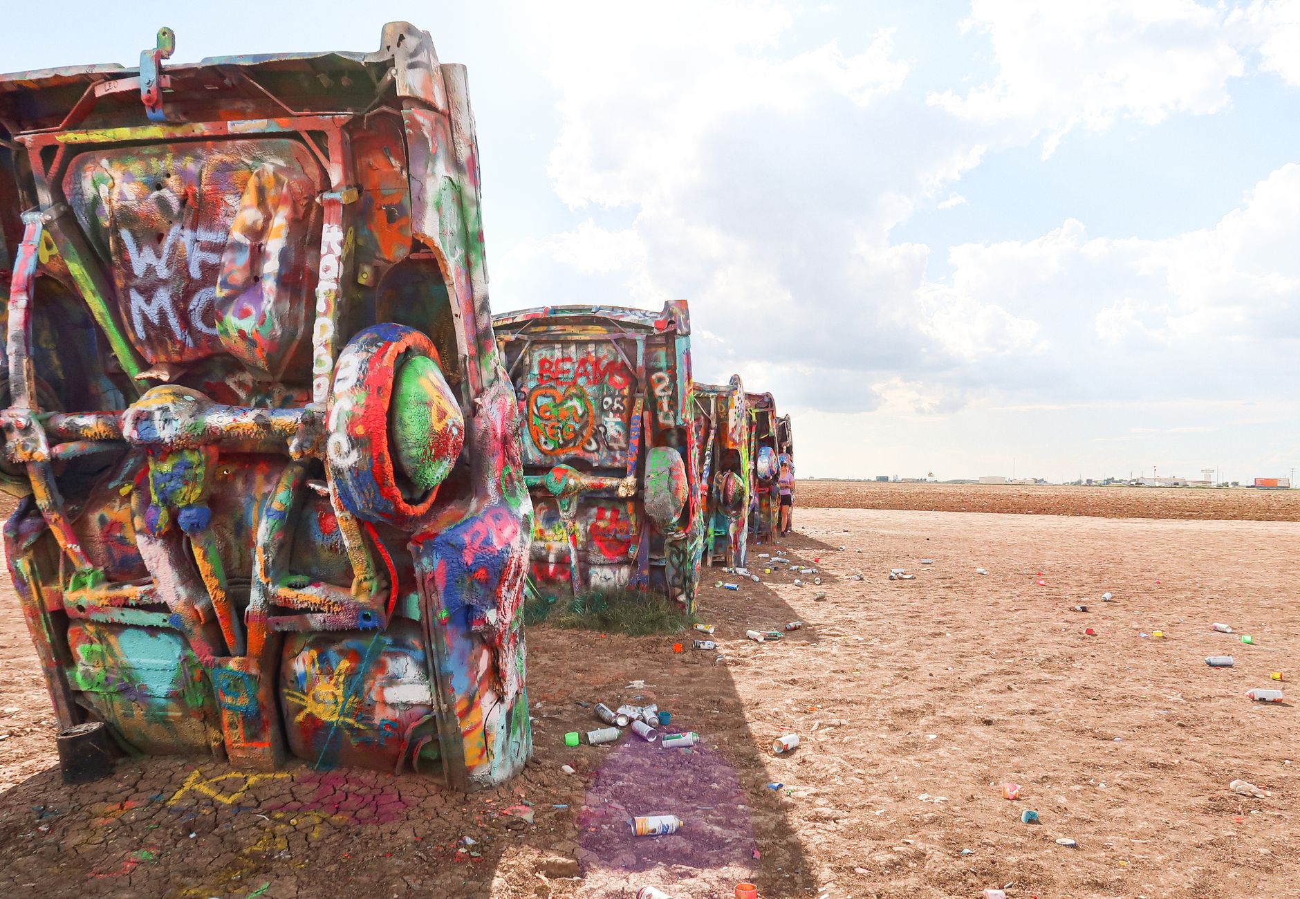 Colorful vintage cars covered in graffiti art at the famous Cadillac Ranch, Texas.