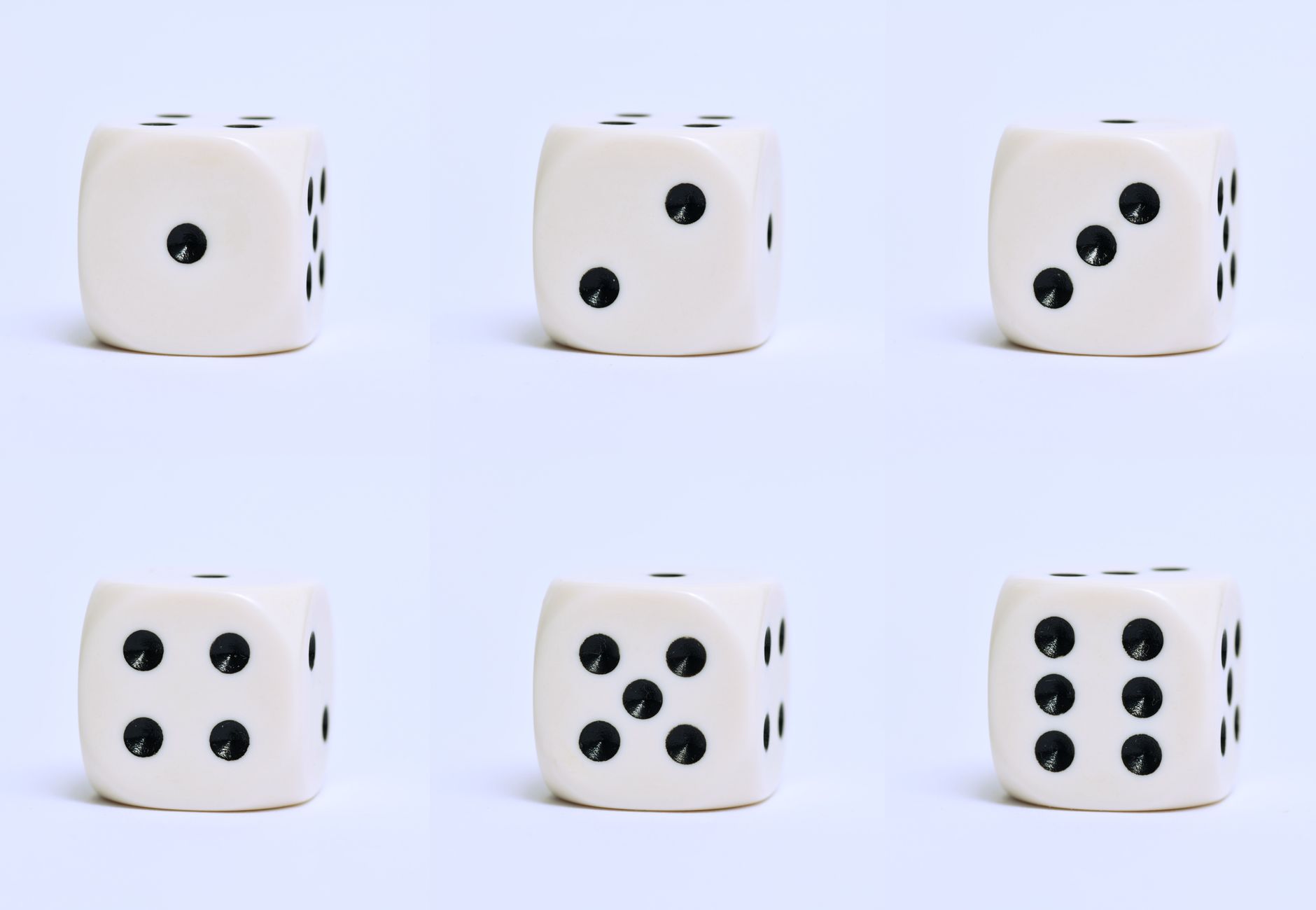 Detailed close-up of six white dice on a plain surface, focusing on different numbers.